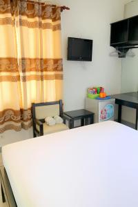 a living room with a couch and a tv at Đại An Hotel Bến Tre in Ben Tre