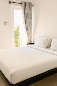 a white bed in a room with a window at Đại An Hotel Bến Tre in Ben Tre +21 photos