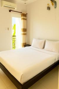 a large white bed in a room with a window at Đại An Hotel Bến Tre in Ben Tre