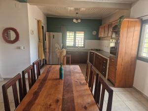a kitchen with a wooden table and chairs in a room at Villa Tahina in Ramena