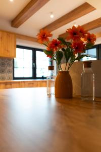 a vase with orange flowers sitting on a table at MonteRai in Văliug