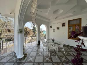 a dining room with a table and chairs on a patio at La Casa by Cosmic Kriya in Bīr