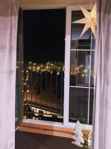 a window with a view of a deck with christmas lights at Penzion Branná in Branná