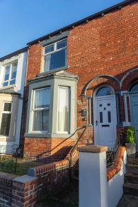 a brick house with a white door and stairs at Comfortable Stay with Free Parking in Carlisle