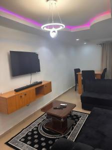 a living room with a tv and a couch and a table at OA luxury apartment 