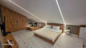 Un dormitorio con una cama en una habitación con paredes de madera. en Cazare Văleanca Lux, 