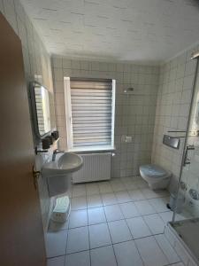 a bathroom with a sink and a toilet and a window at Ferienwohnung Sonnenschein in Dranske +39 photos