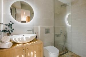 een badkamer met een wastafel, een toilet en een spiegel bij Vinothea Vista in Kefallonia +31 foto's