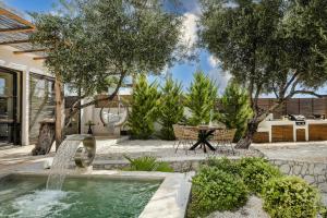 een achtertuin met een fontein en een tafel en stoelen bij Vinothea Vista in Kefallonia