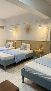 a room with two beds and a table and two tables at A Day Rayong in Ban Pa Khan