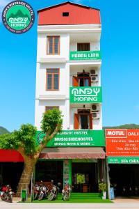 a white building with a tree in front of it at Andy Hoang Riverside Hostel Bar Restaurant Music Beer & More in Ha Giang