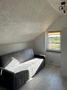 レダにあるCałoroczny domekの窓付きの客室で、大きなソファが備わります。