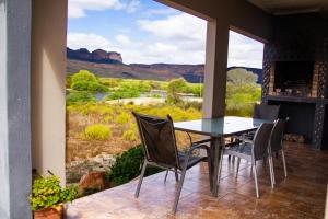 a patio with a table and chairs and a view of the desert at Maskam Guest Farm in Vanrhynsdorp