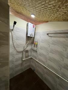 a bathroom with a shower with a phone on the wall at ทองอุไรโฮมสเตย์ ณ แม่สาย in Mae Sai +14 photos