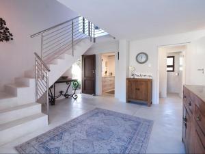 a living room with a staircase and a kitchen at Manhattan Estates - Plettenberg Bay in Plettenberg Bay