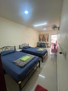 a room with two beds in a room with a window at ทองอุไรโฮมสเตย์ ณ แม่สาย in Mae Sai