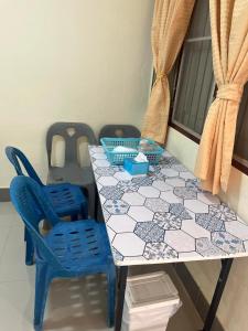 a table with blue chairs and a white and blue tiles at ทองอุไรโฮมสเตย์ ณ แม่สาย in Mae Sai