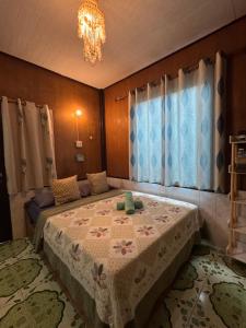 a bedroom with a bed and a chandelier at Small Guest House Koh Kood in Ko Kood