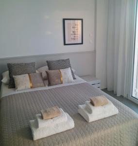 Un dormitorio con una cama grande con toallas. en Sunsets and Olive Trees, en Messini