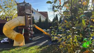 a playground with a slide in a yard at Casa Rosa by MANAGR in Piatra Neamţ