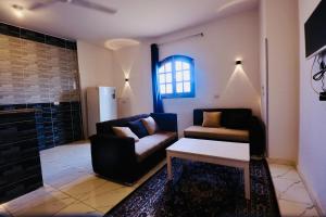 una sala de estar con un sofá y una mesa en Sun wing guest house, en Luxor
