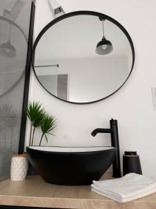 a bathroom with a black tub and a mirror at Malina Residence Aparthotel in Cisnădie +78 photos