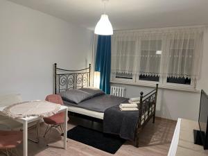 a bedroom with a bed and a table with chairs at Apartament Przytulny przy plaży in Sopot
