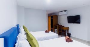 a hotel room with two beds and a tv at Silla Patong Boutique in Patong Beach