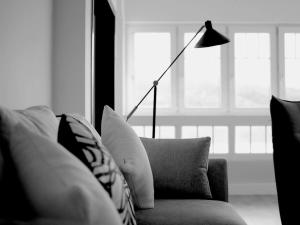 a living room with a couch with pillows and a lamp at LAIDA BEACH by Urdaibai Experience in Ibarrangelu +4 photos