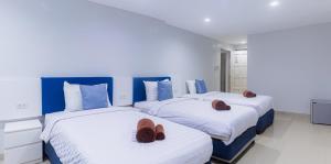 two beds with slippers on them in a bedroom at Silla Patong Boutique in Patong Beach