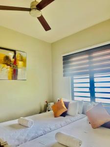 Domaine Des Alizees Residence في غراند بايَ: غرفة نوم بها سريرين ومروحة سقف +8 صور