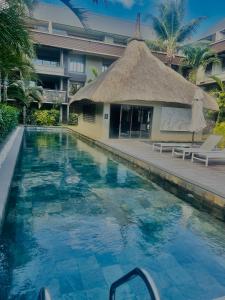 Domaine Des Alizees Residence في غراند بايَ: حمام سباحة أمام مبنى