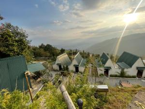 une rangée de maisons avec un arc-en-ciel dans le ciel dans l'établissement The fun and fitness agro resort, à Mahānkāl