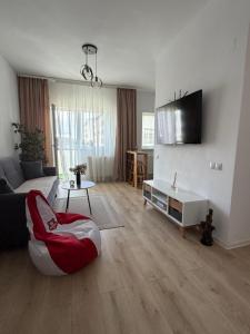 a living room with a couch and a tv at Malina Residence Aparthotel in Cisnădie
