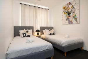 une chambre avec deux lits et un tableau au mur dans l'établissement Spacious Family Coastal Retreat, 4br, Bbq, à Dunsborough