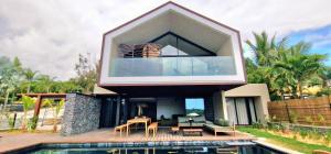 a modern house with a pool in front of it at Le Domaine des Manguiers in Saint-Gilles les Bains