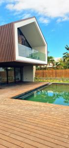 a house with a swimming pool in front of it at Le Domaine des Manguiers in Saint-Gilles les Bains