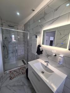 a white bathroom with a sink and a shower at Rive gauche Rive droite 2 Appartements côte à côte neufs et bien équipés in Le Creusot +18 photos