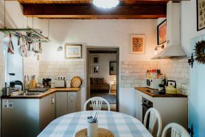 a kitchen with a table and a kitchen with a stove at Kiskovász Pajta & Inn in Nagytevel