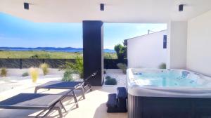 a hot tub in a patio with a table and chairs at Villa 1 in Kožino +50 photos