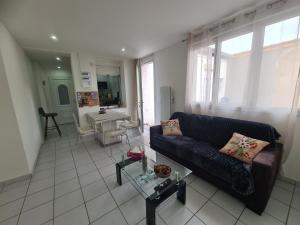 a living room with a couch and a kitchen at Rive gauche Rive droite 2 Appartements côte à côte neufs et bien équipés in Le Creusot