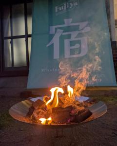 un plato de comida en llamas frente a un letrero en 貸切古民家 海まで徒歩3分 富士山の見える海岸 最大14名宿泊 家族親戚 帰省 合宿 BBQ Japanese ミクソロジーハウスふじや Mixology House Fujiya, en Shizuoka