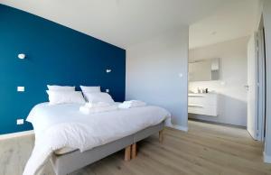 een slaapkamer met een groot bed met een blauwe muur bij Villa Ty Billou in Santec +18 foto's