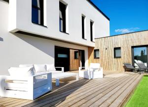 een houten terras met witte meubels op een huis bij Villa Ty Billou in Santec