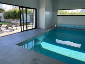 een zwembad met blauw water in een huis bij Villa Ty Billou in Santec