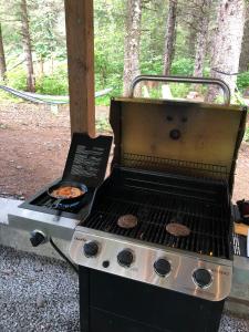 a grill with hamburgers on top of it at Nauti Otter Inn and Yurt Village in Bear Creek