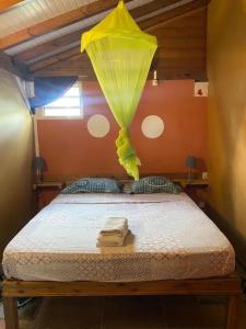 a bedroom with a bed with a yellow parachute above it at Bungalow cosy à Capesterre-Belle-Eau avec piscine in Petites Mamelles