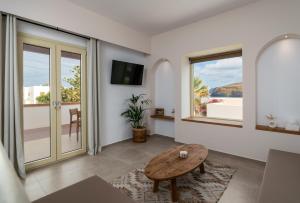 a living room with a table and a view of the ocean at Vive Mare Milos in Pachaina