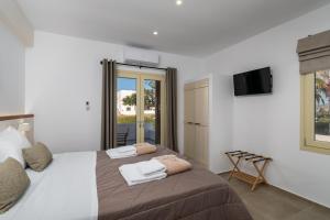 Un dormitorio con una cama grande con toallas. en Vive Mare Milos, en Pachaina 27 fotos más