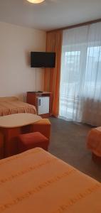 アラドにあるVila Queenのベッド2台と薄型テレビ付きのホテルの部屋